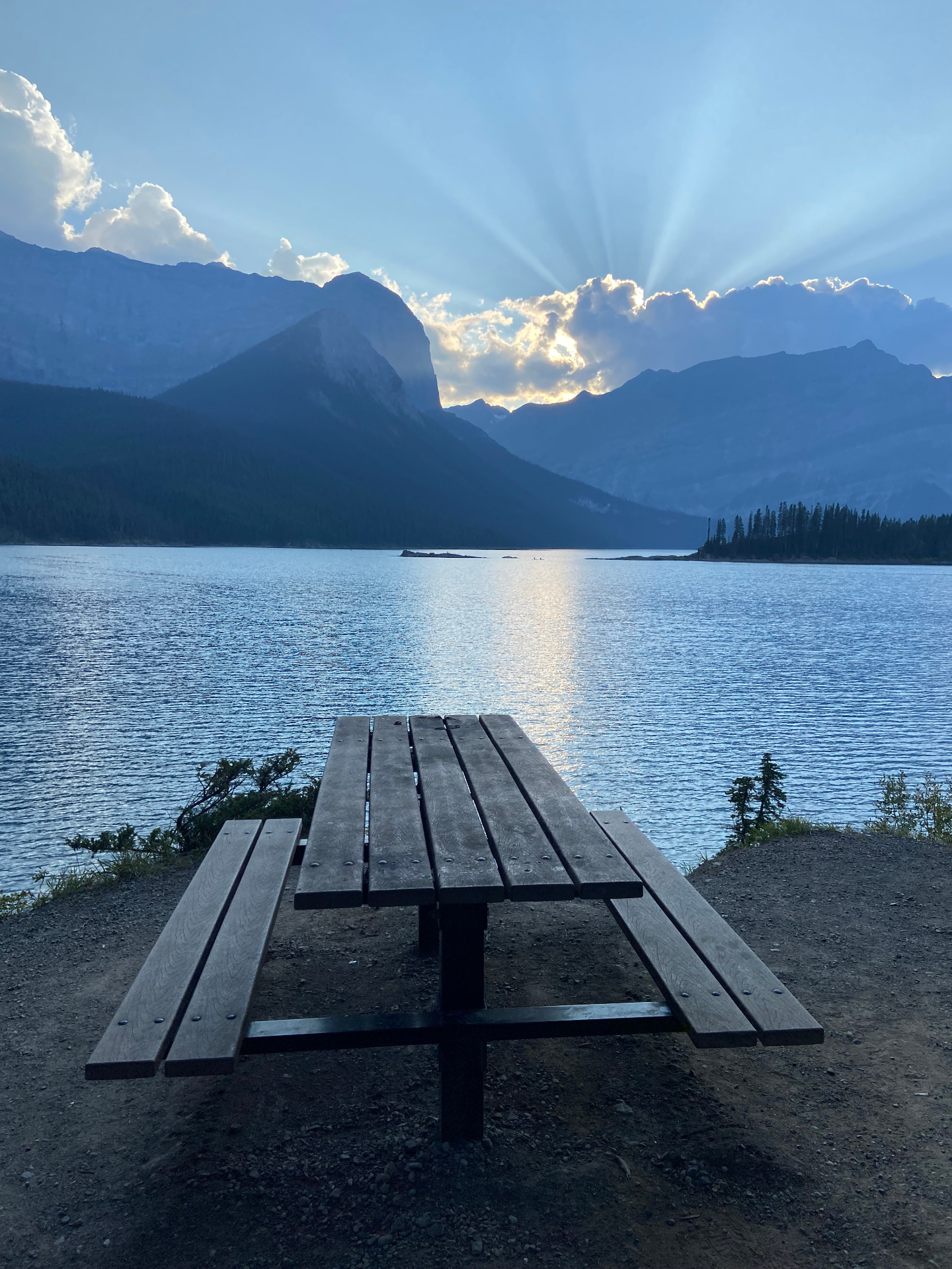 Sunrays over a mountain lake in Kananaskis at golden hour