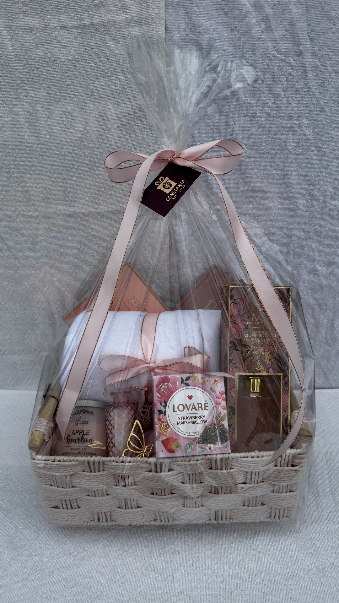 Phone photo of a curated pink gift basket wrapped in cellophane